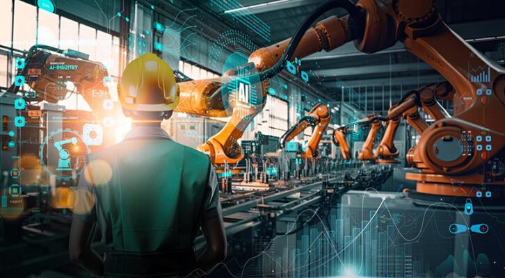 A person in a hard hat oversees AI-driven robotic arms and IoT-enabled digital interfaces in a high-tech manufacturing setting.