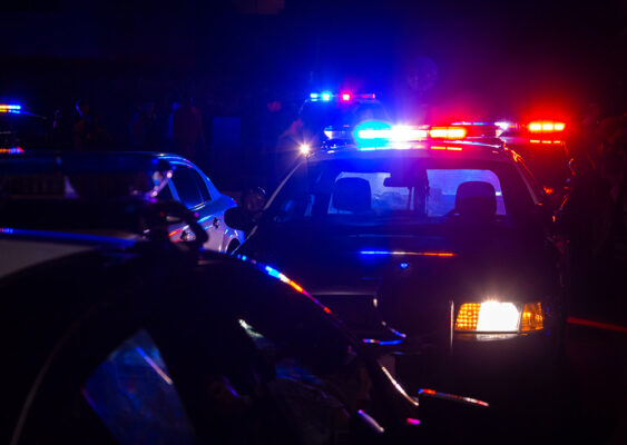 Police cars in a parking lot at night are ready for their mission-critical duties.