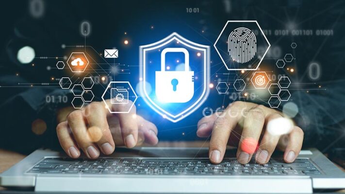 Hands typing on a keyboard, overlaid digital security icons like a lock and a fingerprint, reflecting an IoT security strategy.