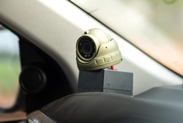 A video telematics camera mounted on the dashboard inside a vehicle.