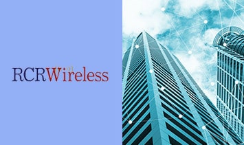 Rcr wireless logo with buildings in the background.