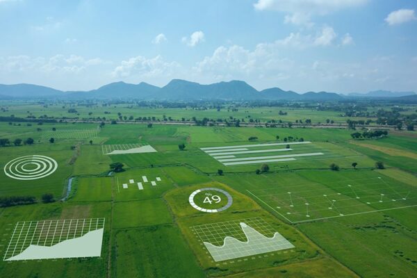 Aerial view of farmland with digital graphics overlaying data charts and statistics on agriculture fields.