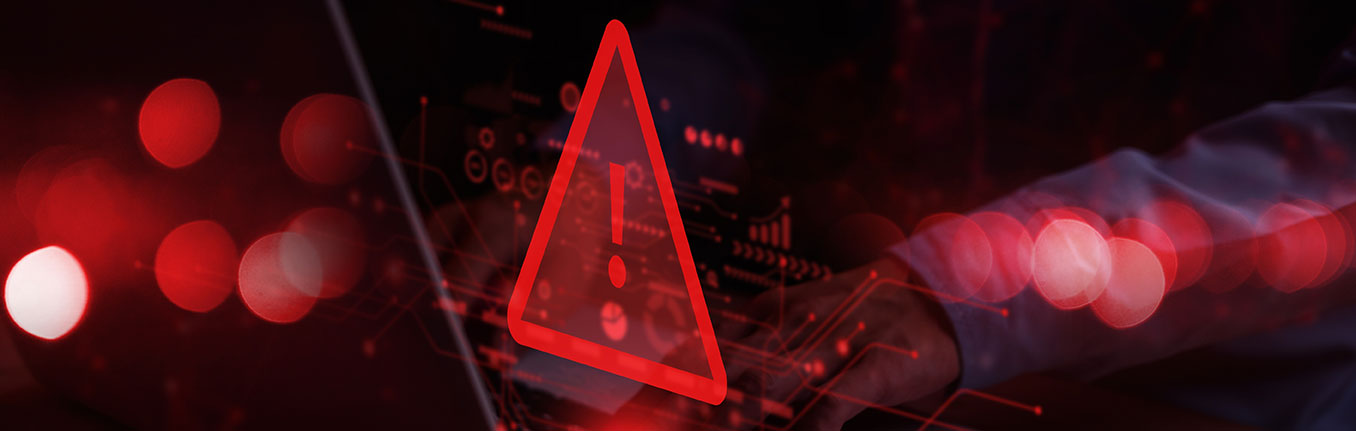 A person typing on a laptop, overlaid with a large red warning triangle.