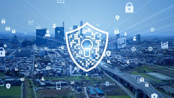 Digital security concept illustrated with a shield and keyhole symbol superimposed over a cityscape, surrounded by various technology icons, highlighting the importance of IoT cybersecurity.