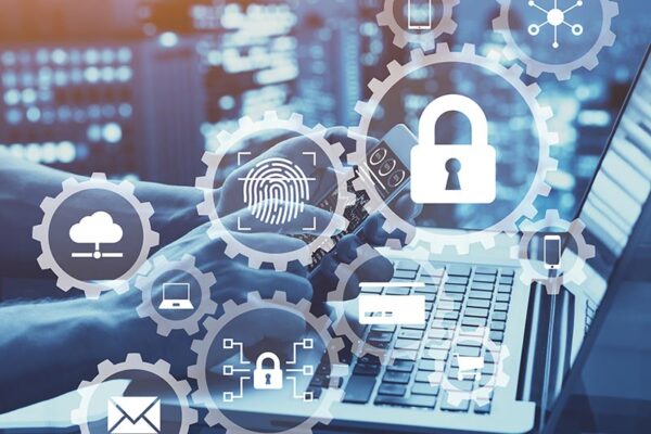 Hands typing on a laptop keyboard with digital security icons, including a lock and a fingerprint, superimposed over the image, emphasizing IoT cybersecurity.
