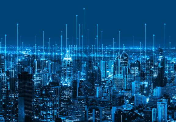 An image of a city at night with blue lines showcasing a smart grid.