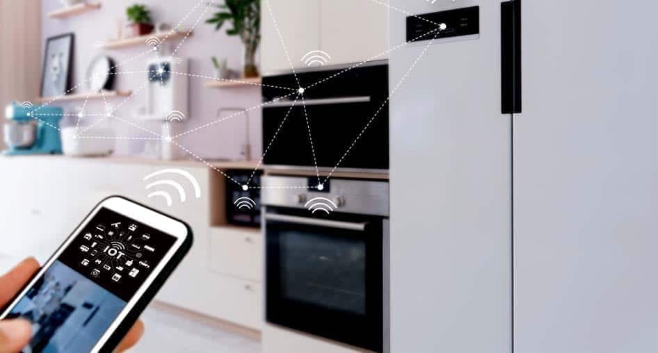 A person holding a smartphone controlling their smart home appliances with IoT, overlaid with signal and geometric lines.