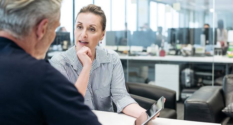 Two people in an office looking at a tablet. Being able to manage your devices from one intuitive interface can avoid problems with your IoT deployment.