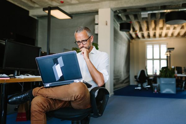 A person with a pensive expression looking at a laptop. Security is critical for enterprise environments in which there are many different devices and users connecting to the same network.