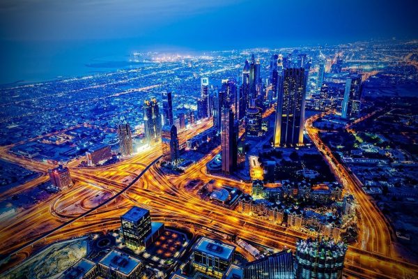 Aerial view of city at night with motion blur from vehicle headlights on the highways.