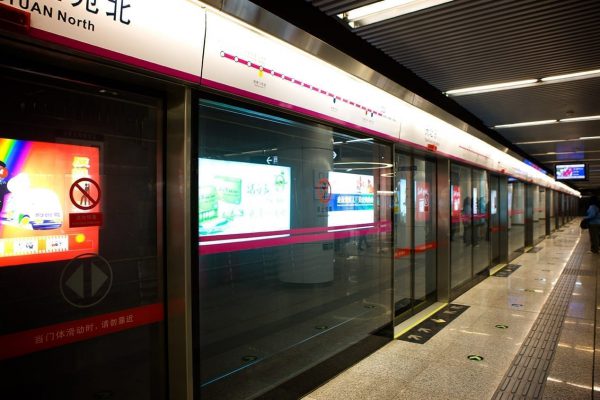 Storefronts at a train station in Asia with digital signage monitors in the windows.