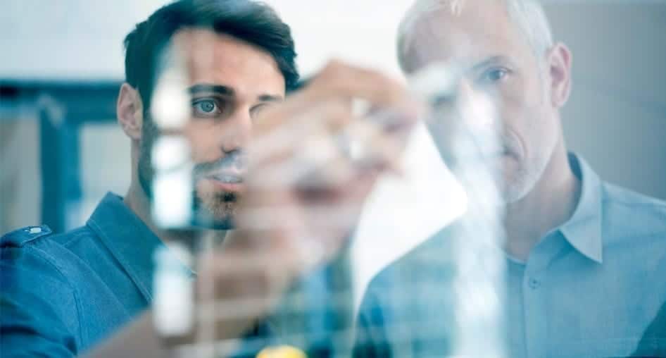 Two men looking at a computer screen.