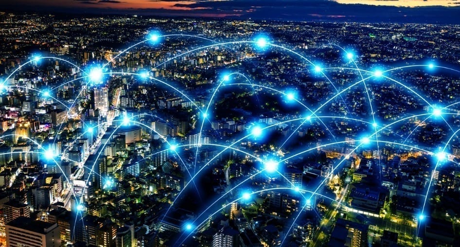 Aerial view of a city at night with glowing dots connected with lines.