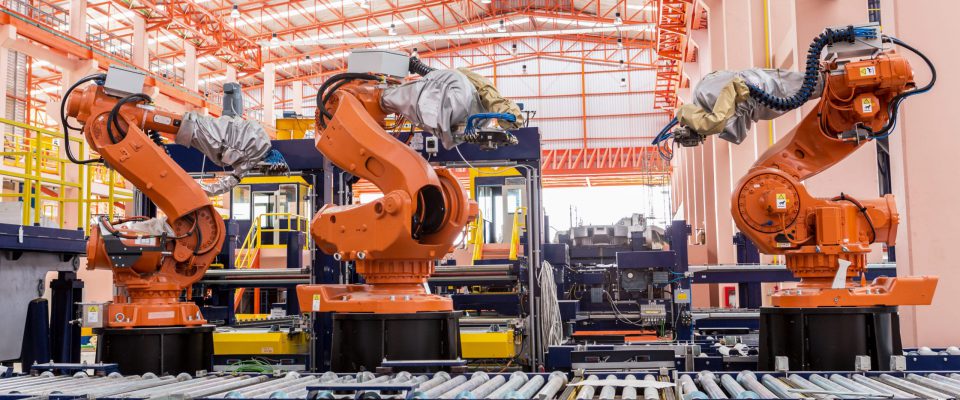 A group of orange robots in a factory.