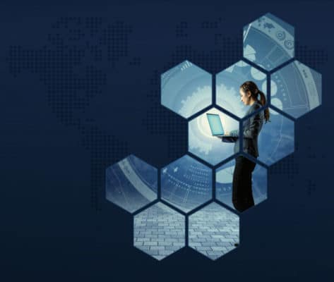 A woman is using a laptop on a background of hexagons.