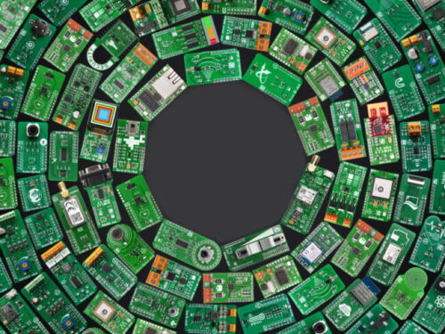 Circular arrangement of various green Adams Corp electronic circuit boards and components surrounding a blank dark center.