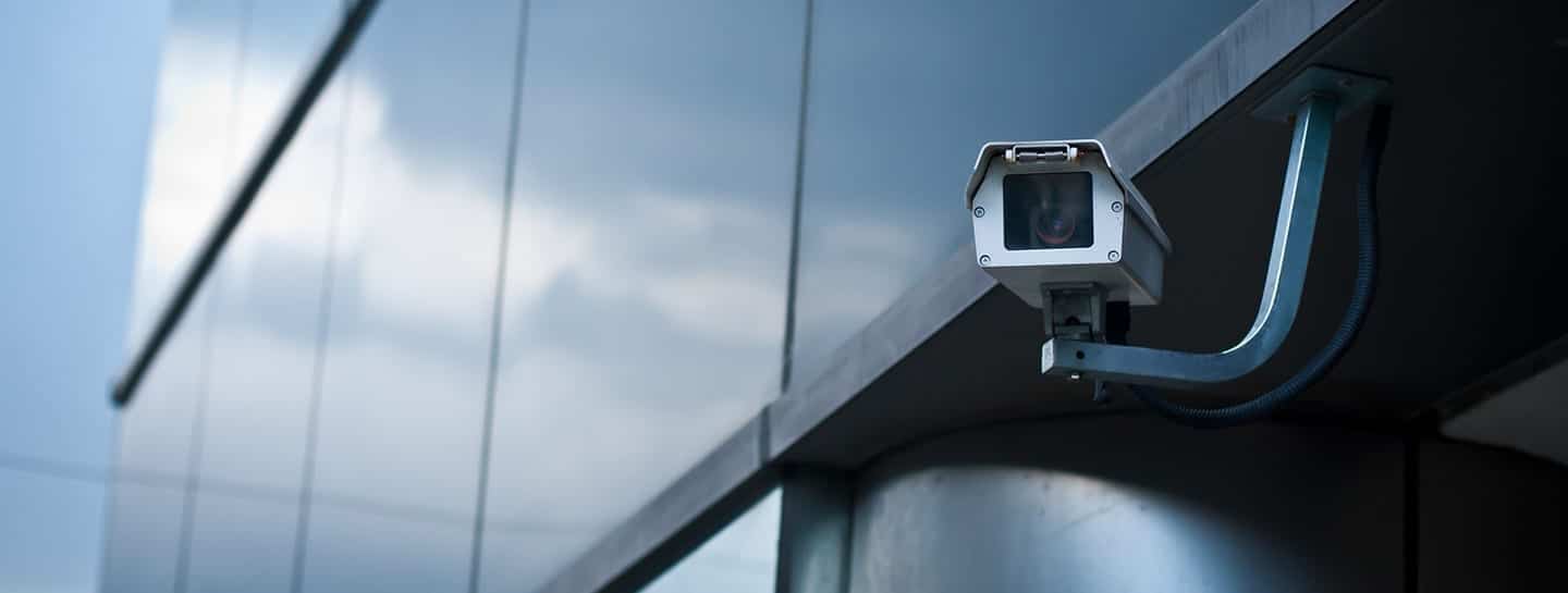 A smart security camera installed on the side of a building for surveillance purposes.