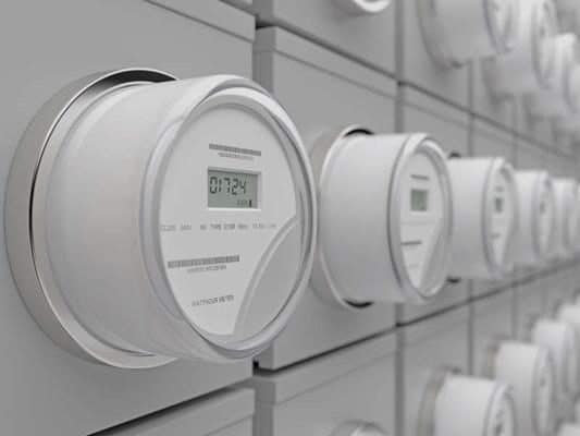 A row of digital energy meters on a wall.