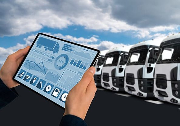Digital tablet displaying fleet analytics with fleet of trucks in the background.