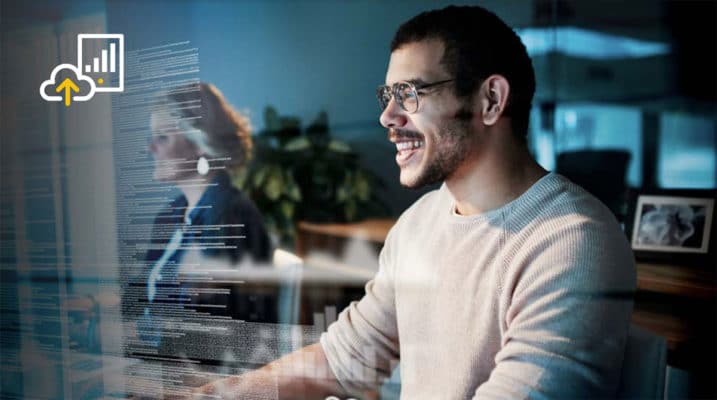 A man is sitting in front of a computer screen.