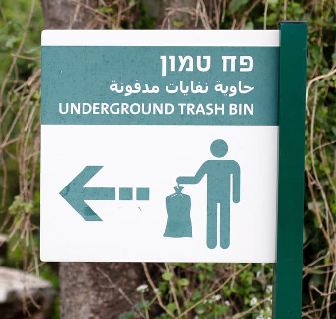 A sign pointing the way to an underground trash bin in Jerusalem.