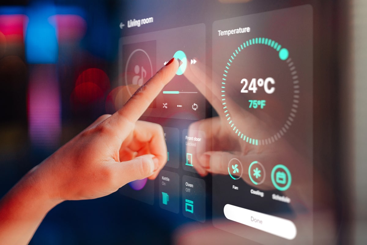 A person is pointing at a digital screen displaying a thermometer, showcasing IoT connectivity solutions.