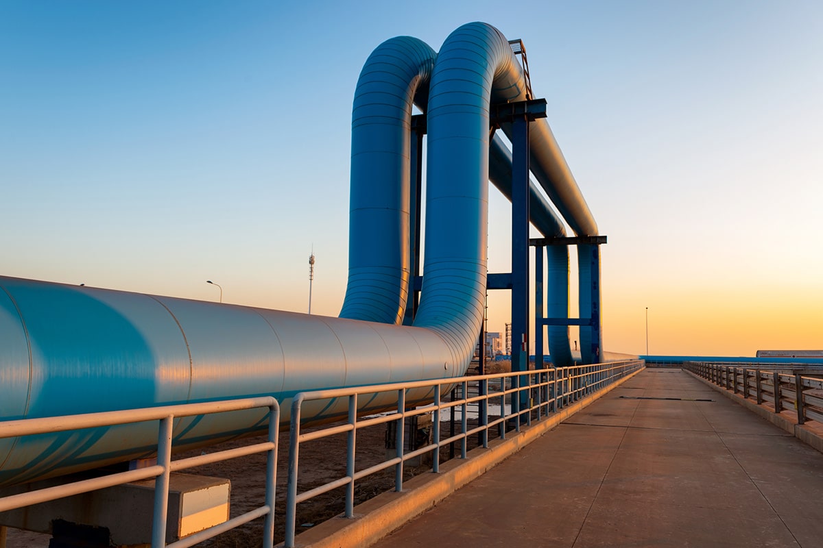 A blue pipe with a sunset in the background, highlighting the integration of IoT utilities for smart energy efficiency.