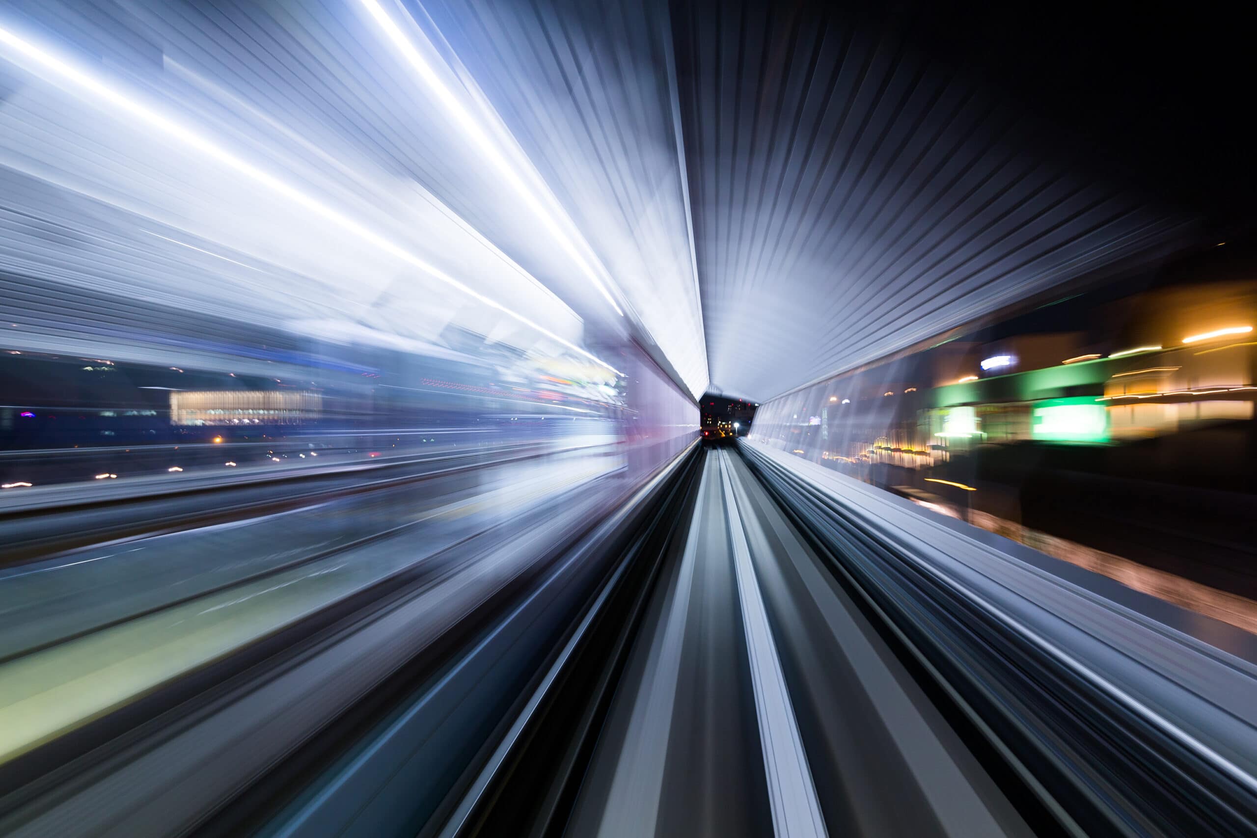 A blurry image of a train moving at night on the edge.