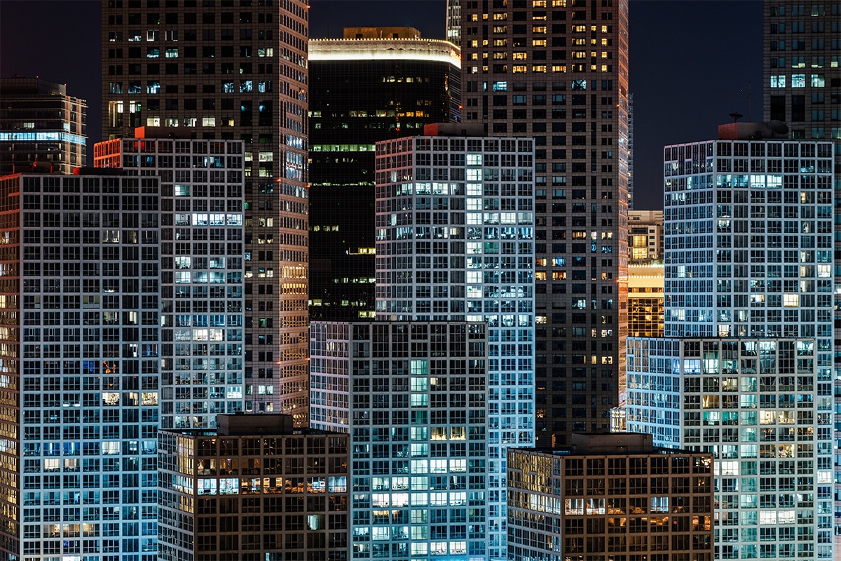 A city at night with many buildings lit up thanks to smart lighting.