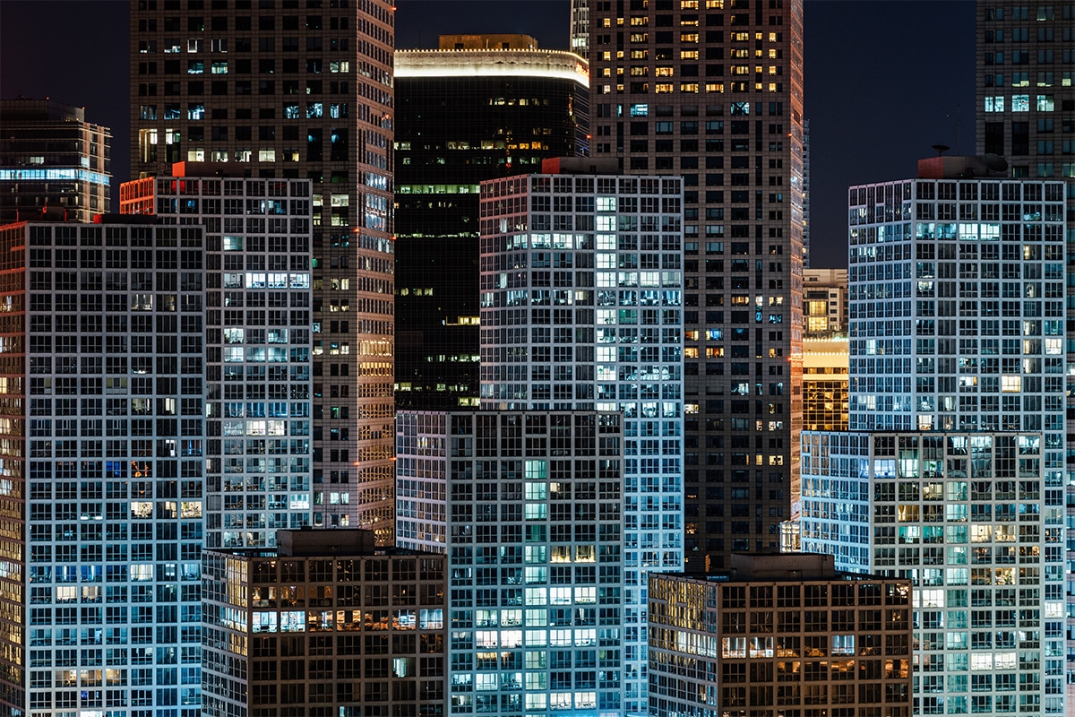 A city at night with many buildings lit up thanks to smart lighting.