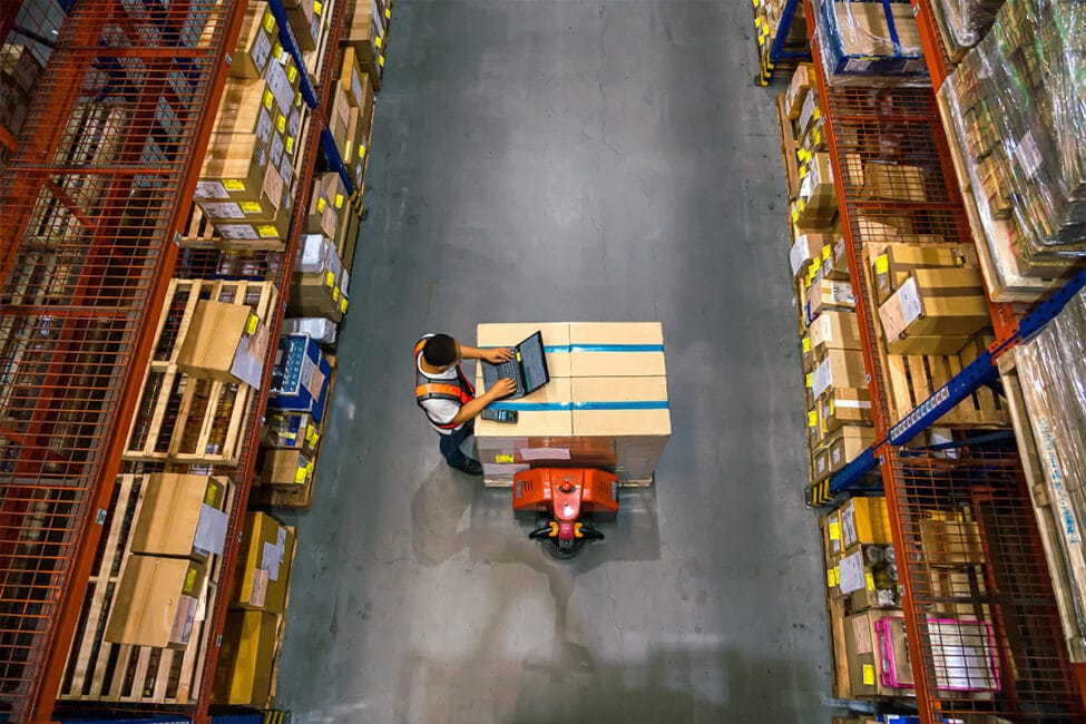 A worker is moving boxes in a food warehouse.