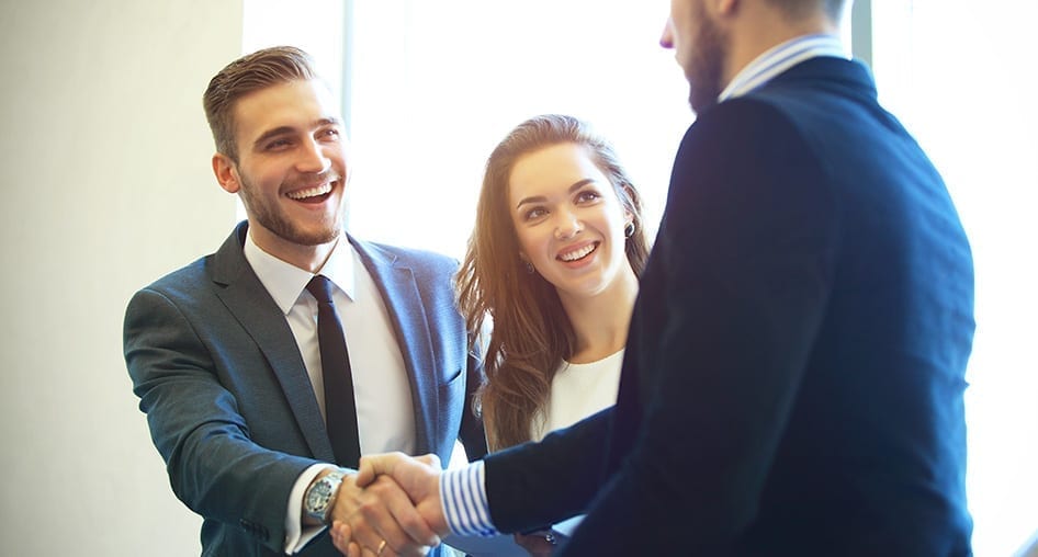 Two business people shaking hands in an office.