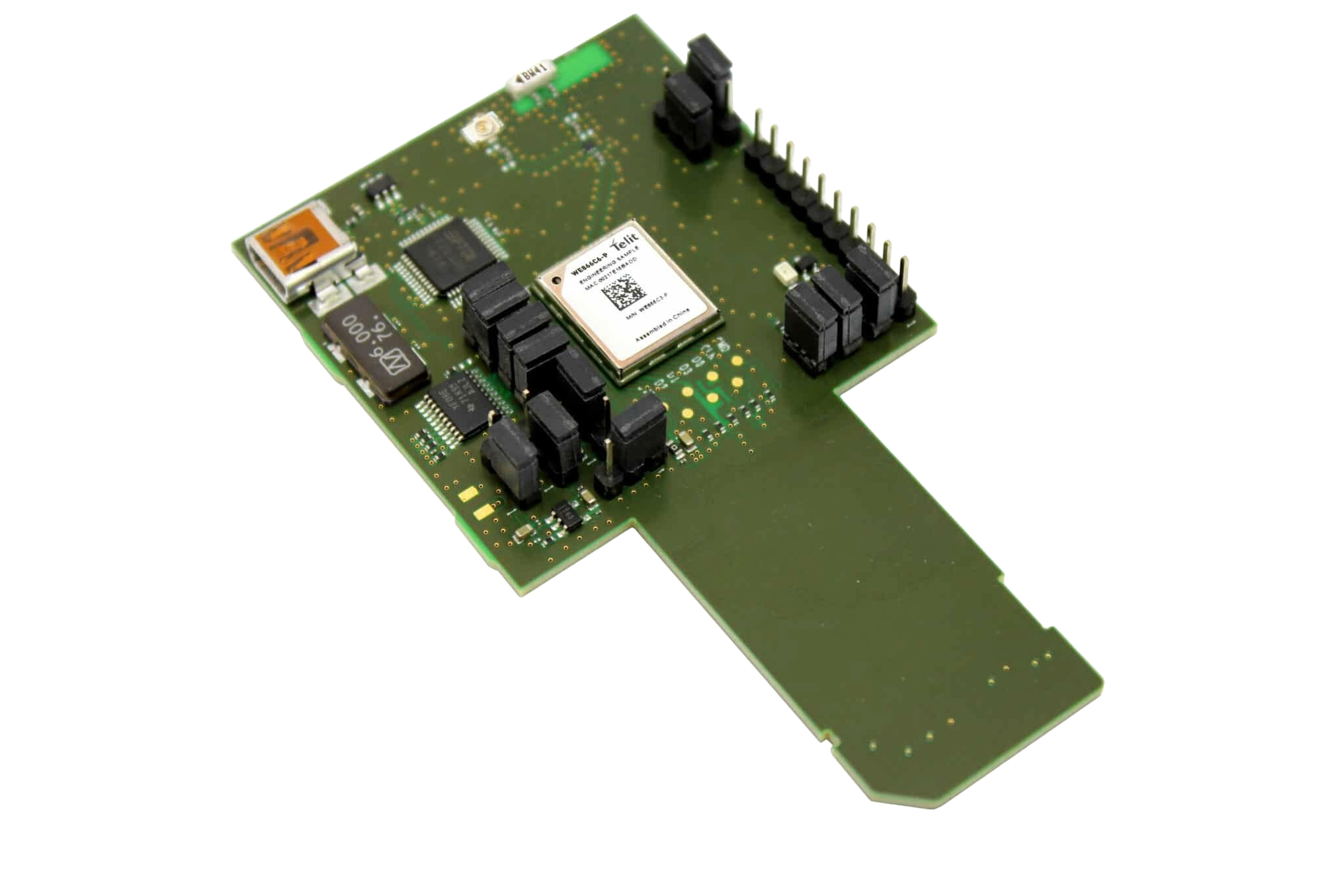 A green board with a number of electronic components on it.