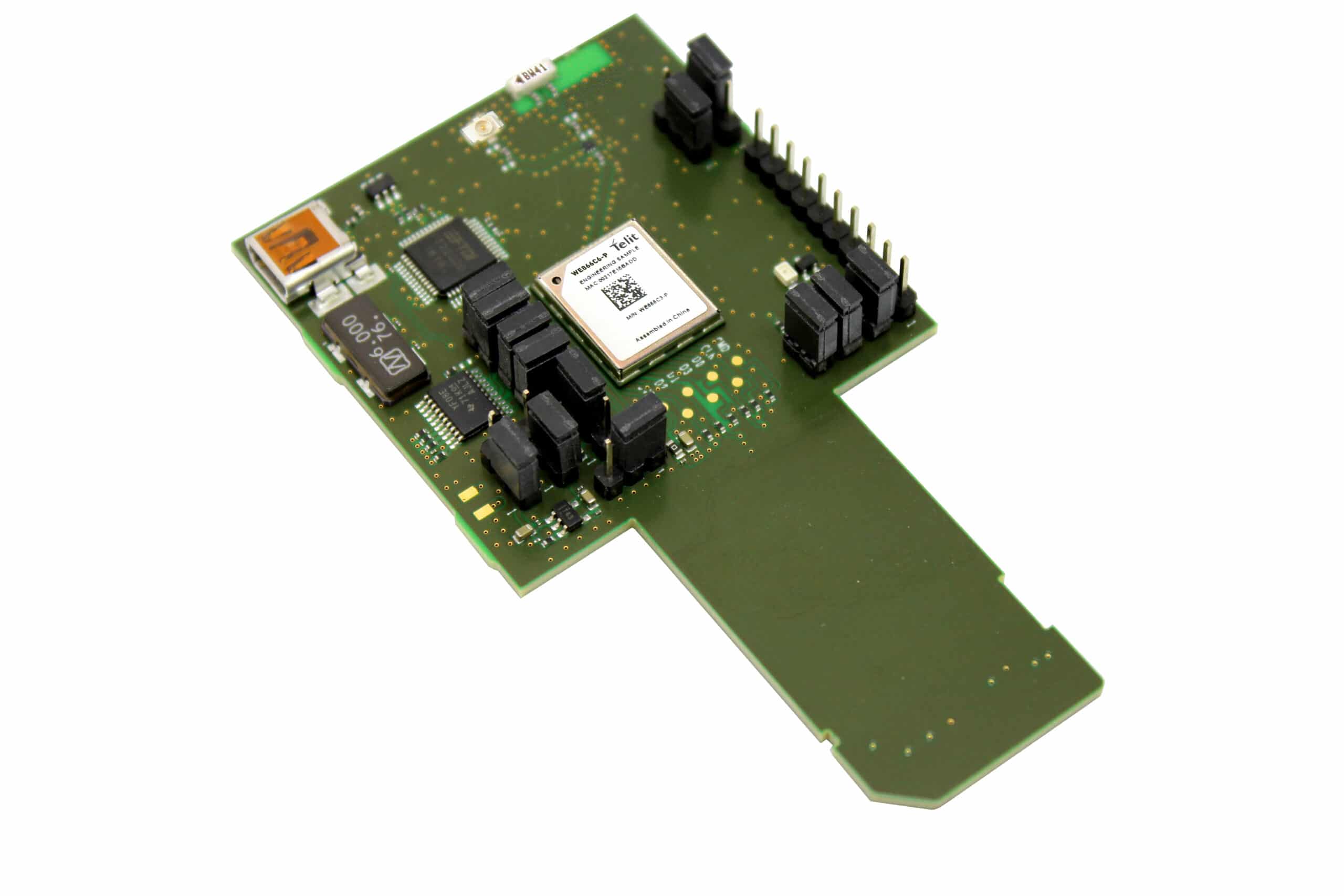 A green board with a number of electronic components on it.