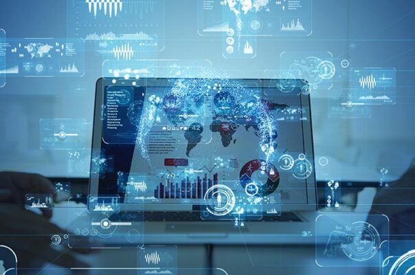 A laptop screen displays digital analytics and data visualizations, with a transparent world map overlay.