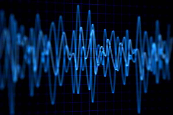 Blue waves are displayed against a dark, grid-like background, showing varying amplitude and frequency.