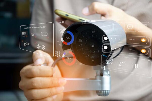 Digital graphics overlay a person holding a security camera and a smartphone.