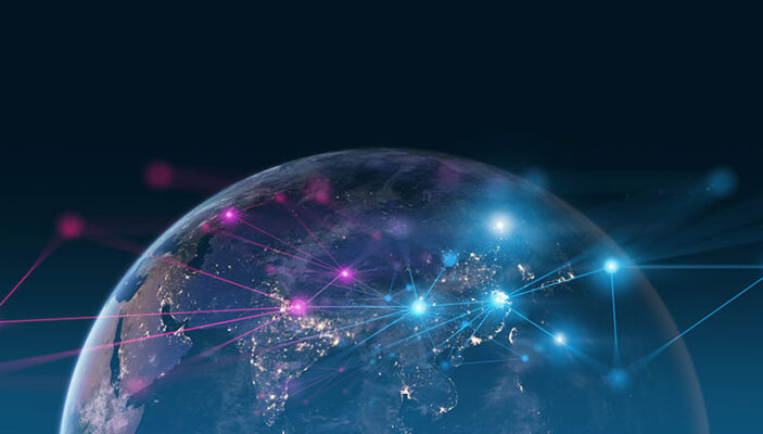 A digital rendering of Earth from space, showing illuminated continents with colorful lines connecting various locations, symbolizing global connectivity and communication through 5G technology and IoT.