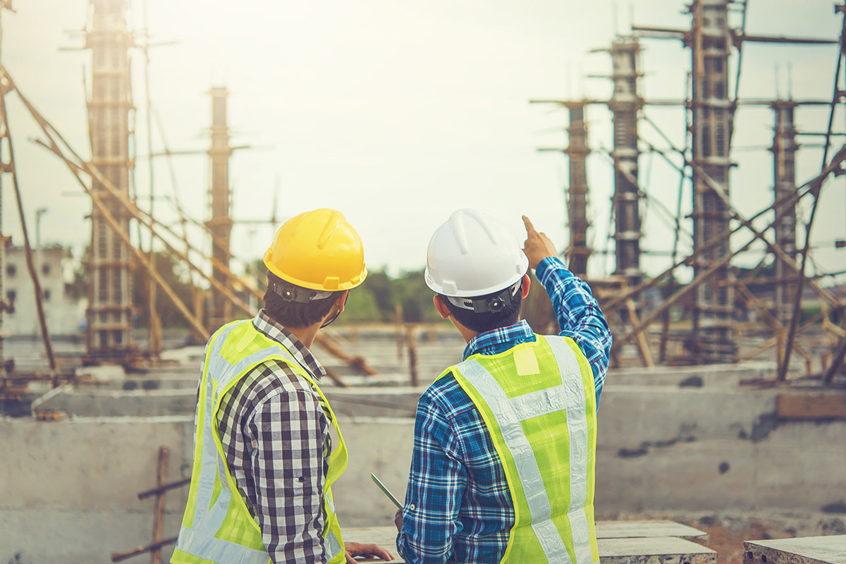 Two construction workers standing on a IoT construction site.