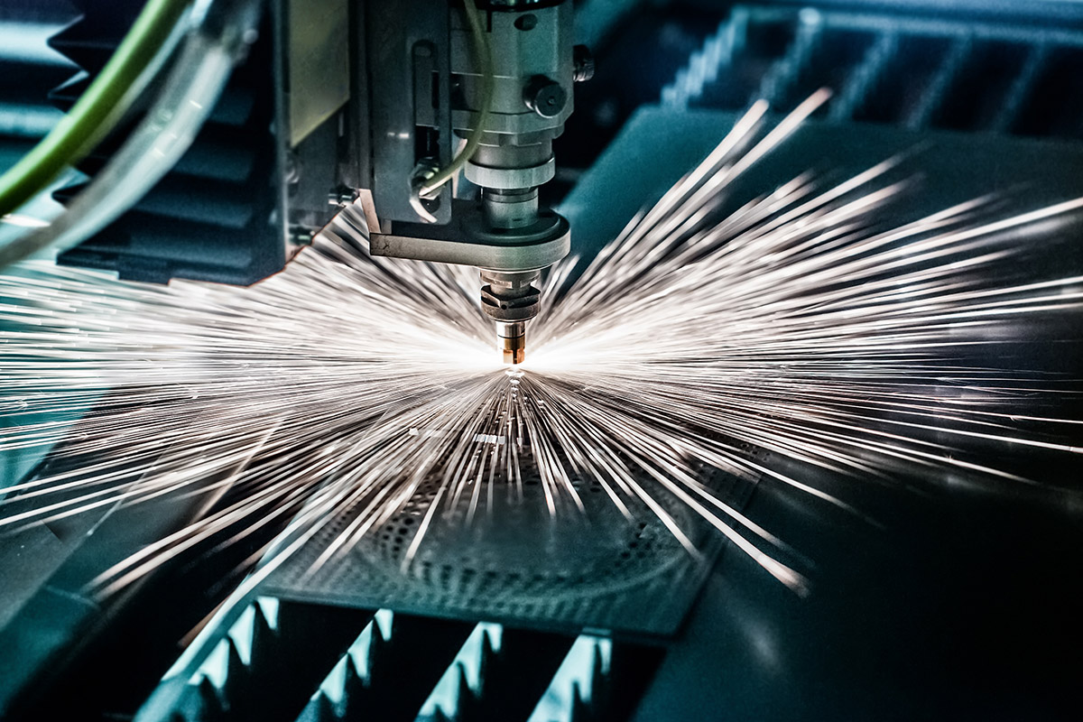 A mechanical tool in an industrial setting, with sparks flying out as it works.