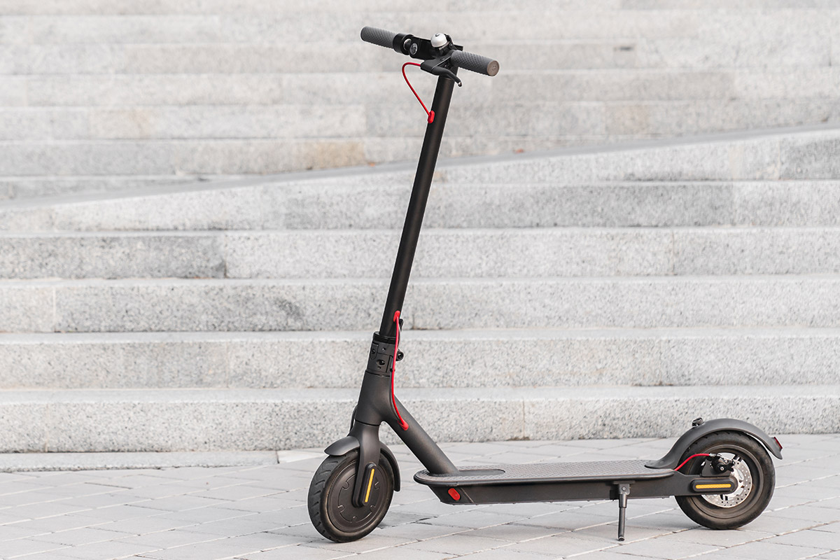 An electric scooter is parked on the steps, showcasing a blend of IoT technology.