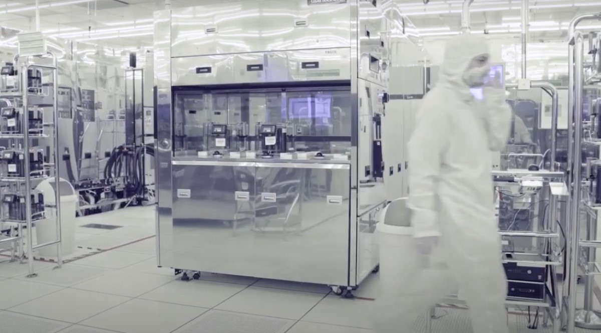 A man in a white suit walks through a secureWISE factory.