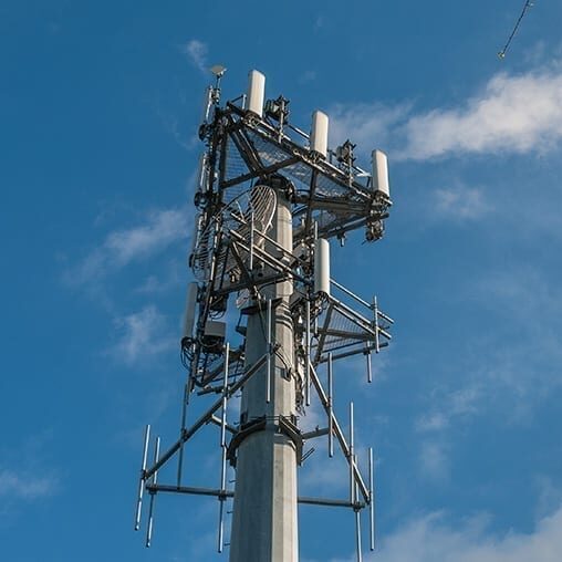 Cellular tower against a partly cloudy sky.