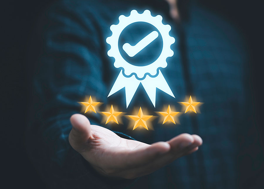 Businessman holding and showing the best quality assurance with golden five stars for guarantee product. Passing IoT regulation and compliance tests and earning certifications leads to greater trust in your products and services.