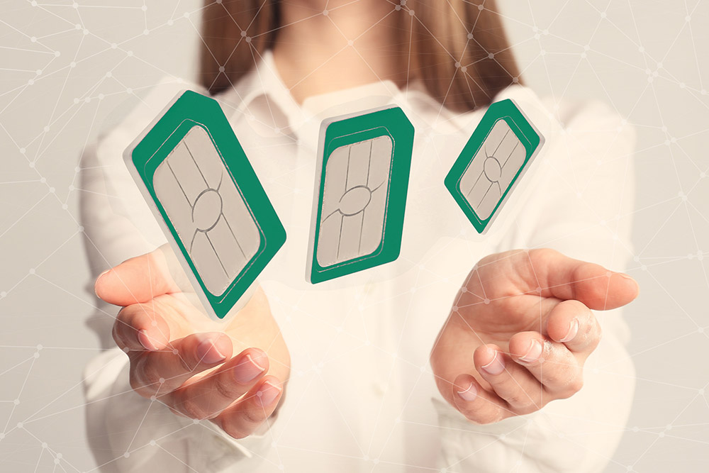 A woman holds multiple sim cards in her hands for prepaid IoT connectivity plans.