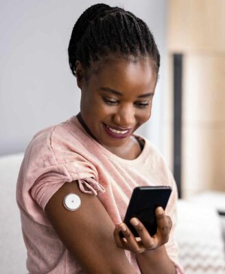 Woman using her phone to monitor her glucose levels