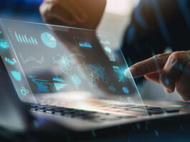 Person working on a laptop with a screen displaying data analytics.