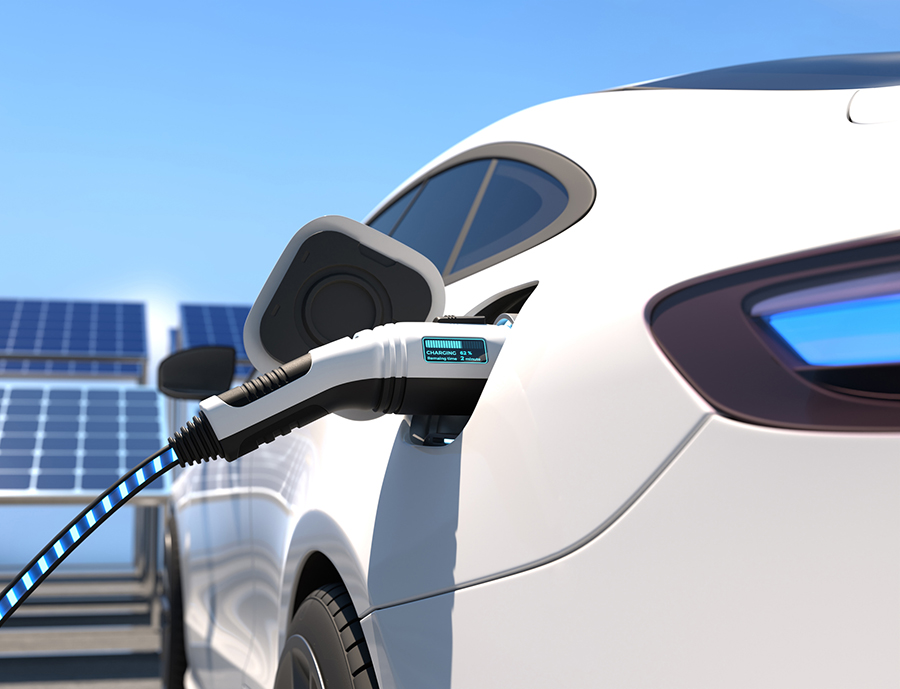 An electric vehicle charging at an EV charging station powered by solar panels.