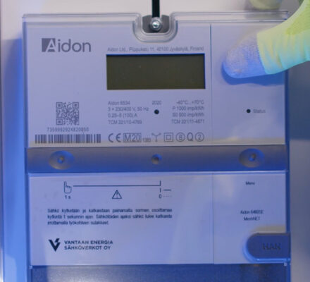 Aidon meter installation with hand in a yellow glove.
