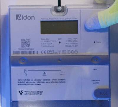 Aidon meter installation with hand in a yellow glove.